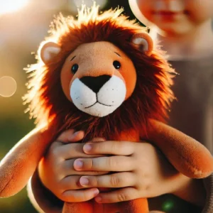 image de la peluche qui représente Aslan, tenu dans les mains d'un petit garçon.