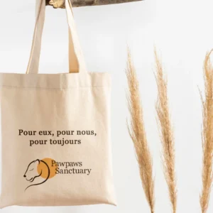 Tote bag soutenu par une branche d'arbre aec le logo pawpaws sanctuary.